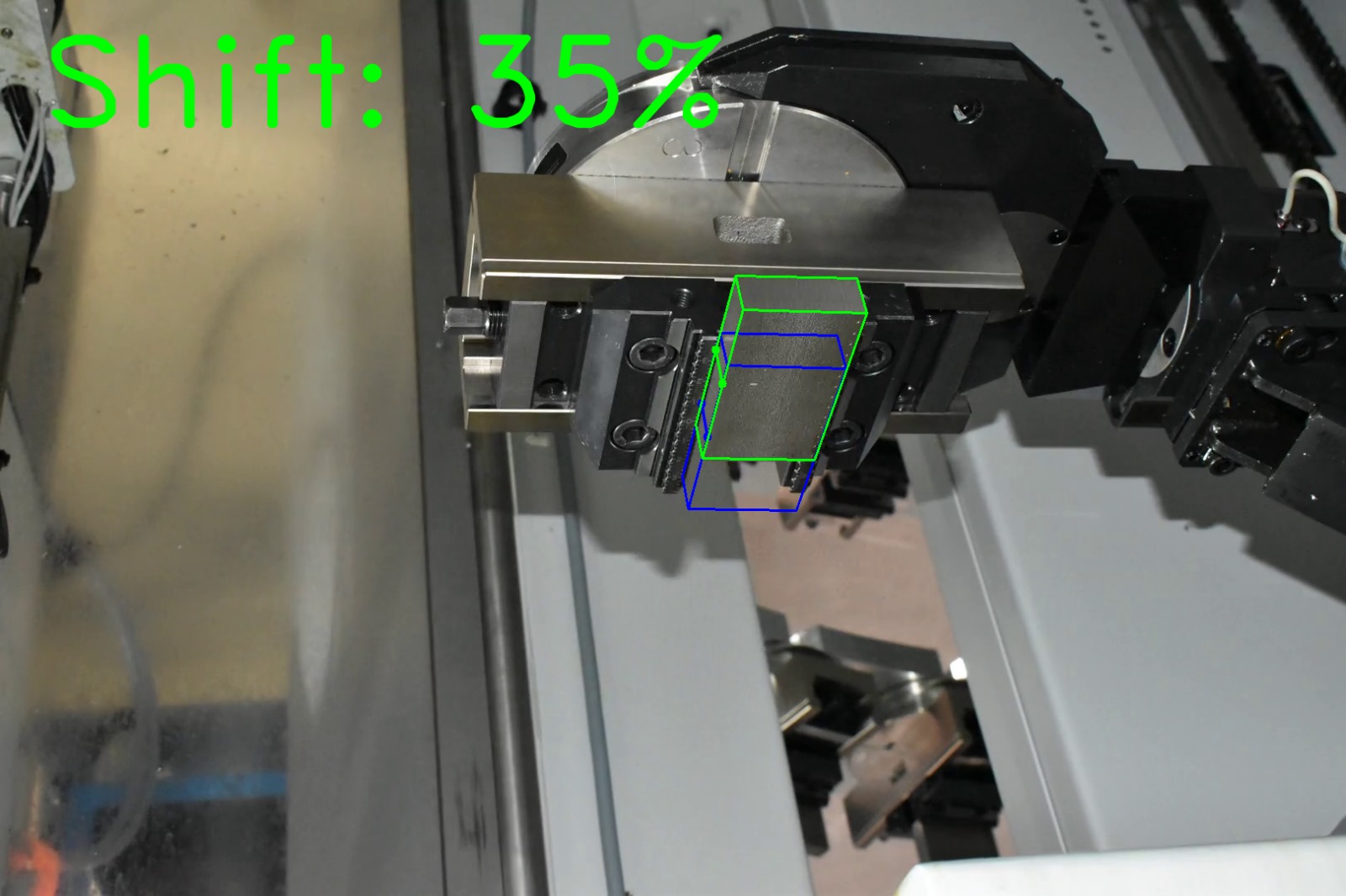 Computer vision shift estimation on factory photograph 1 of a metal block held by a CNC gripper