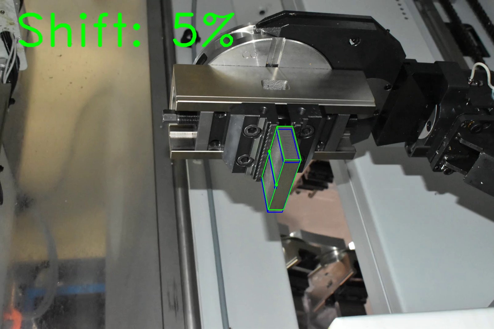 Computer vision shift estimation on factory photograph 2 of a metal block held by a CNC gripper