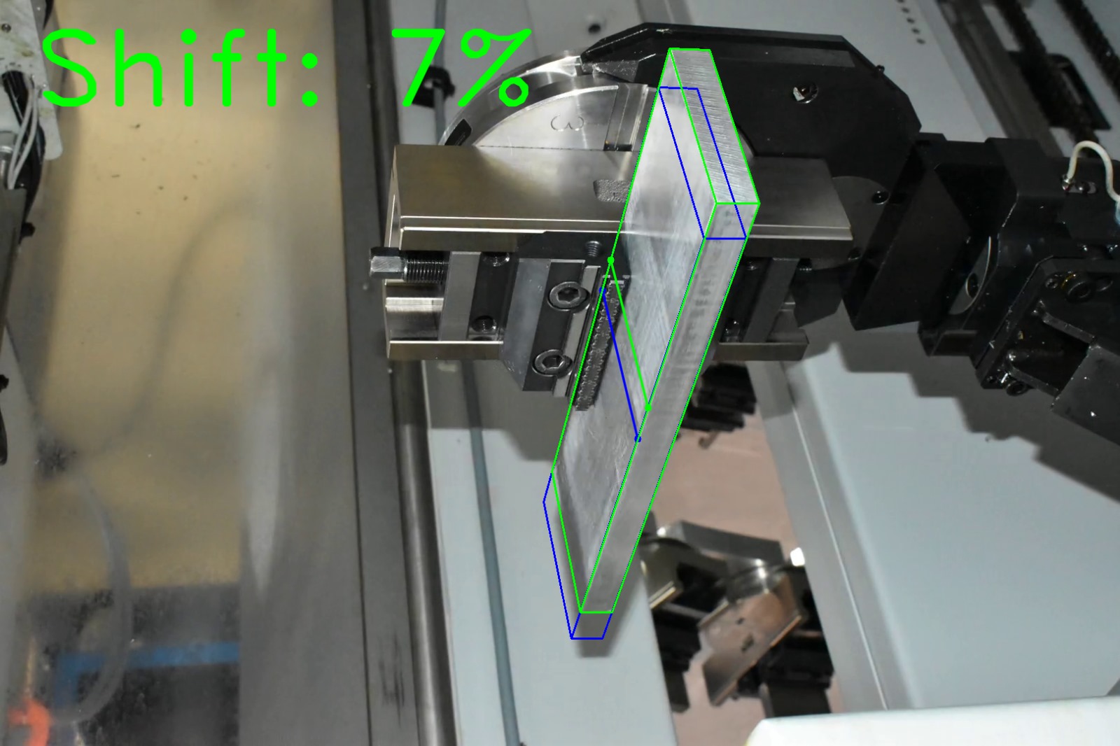 Computer vision shift estimation on factory photograph 3 of a metal block held by a CNC gripper