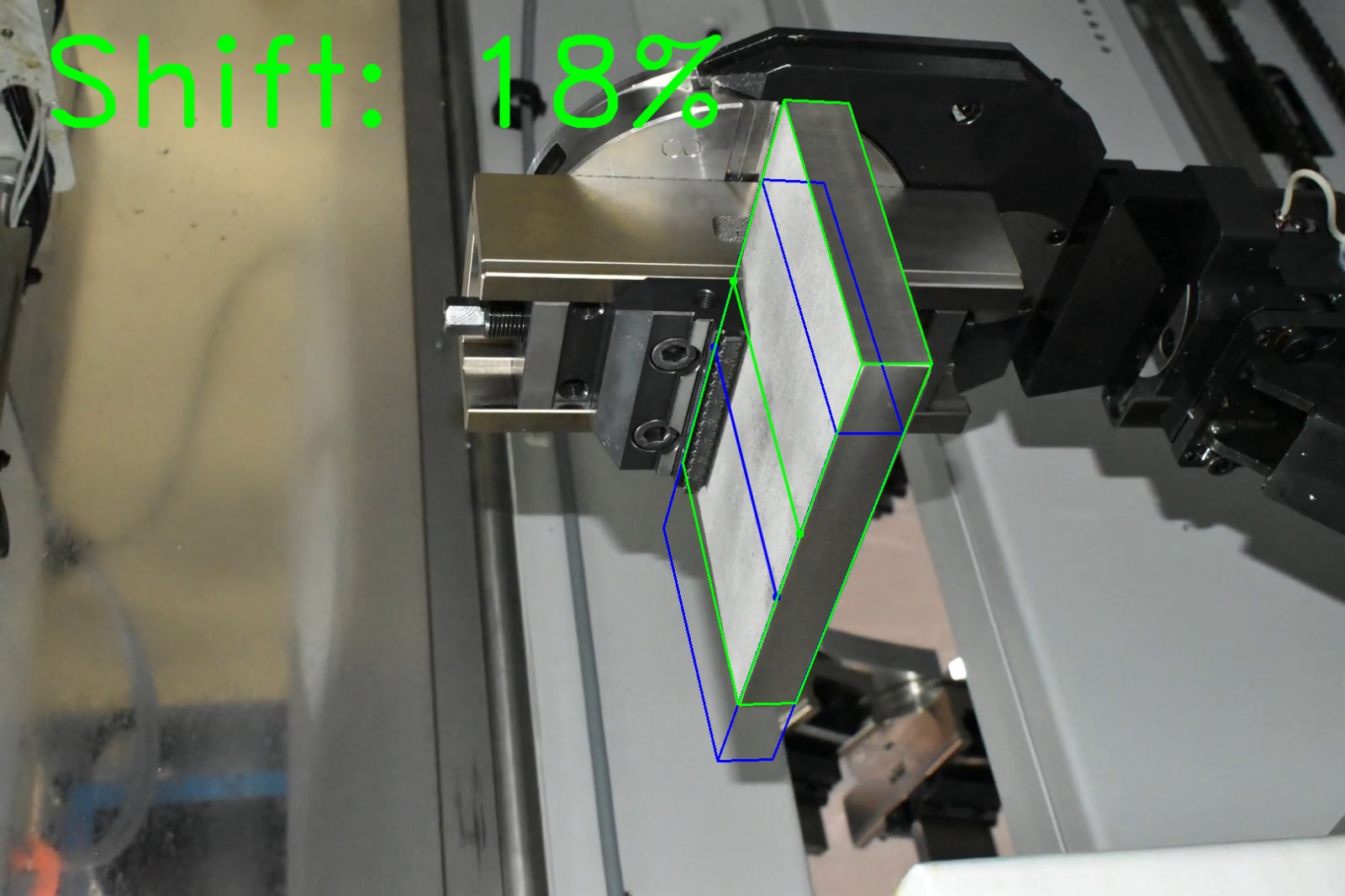 Computer vision shift estimation on factory photograph 5 of a metal block held by a CNC gripper
