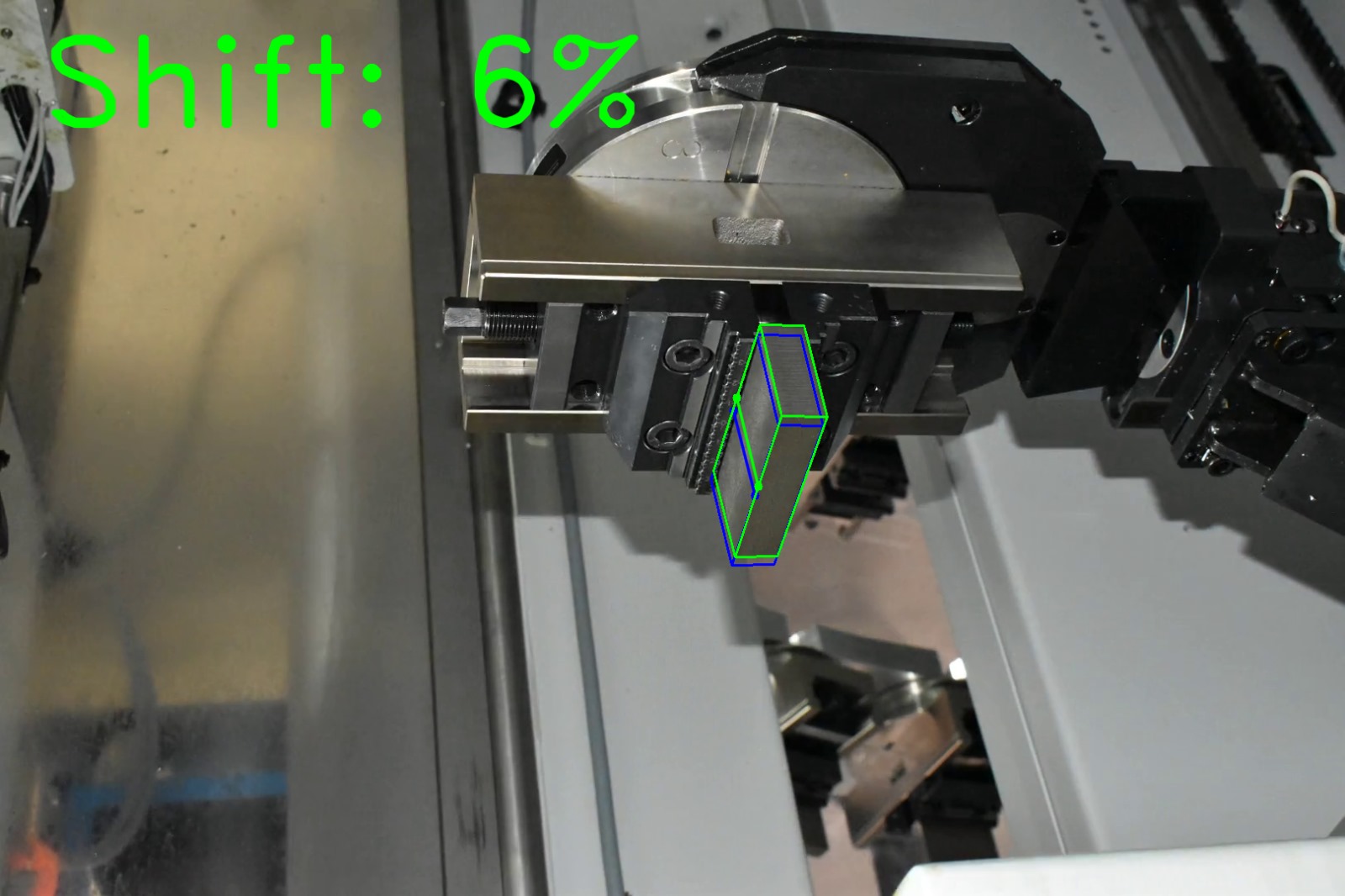 Computer vision shift estimation on factory photograph 7 of a metal block held by a CNC gripper