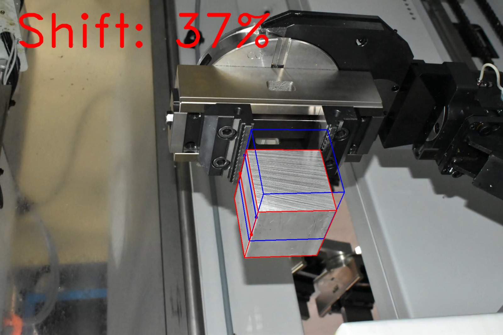 Computer vision shift estimation on factory photograph 12 of a metal block held by a CNC gripper