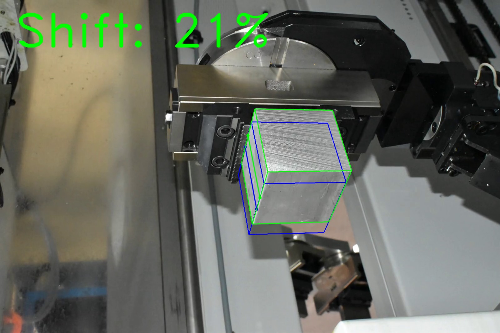Computer vision shift estimation on factory photograph 13 of a metal block held by a CNC gripper