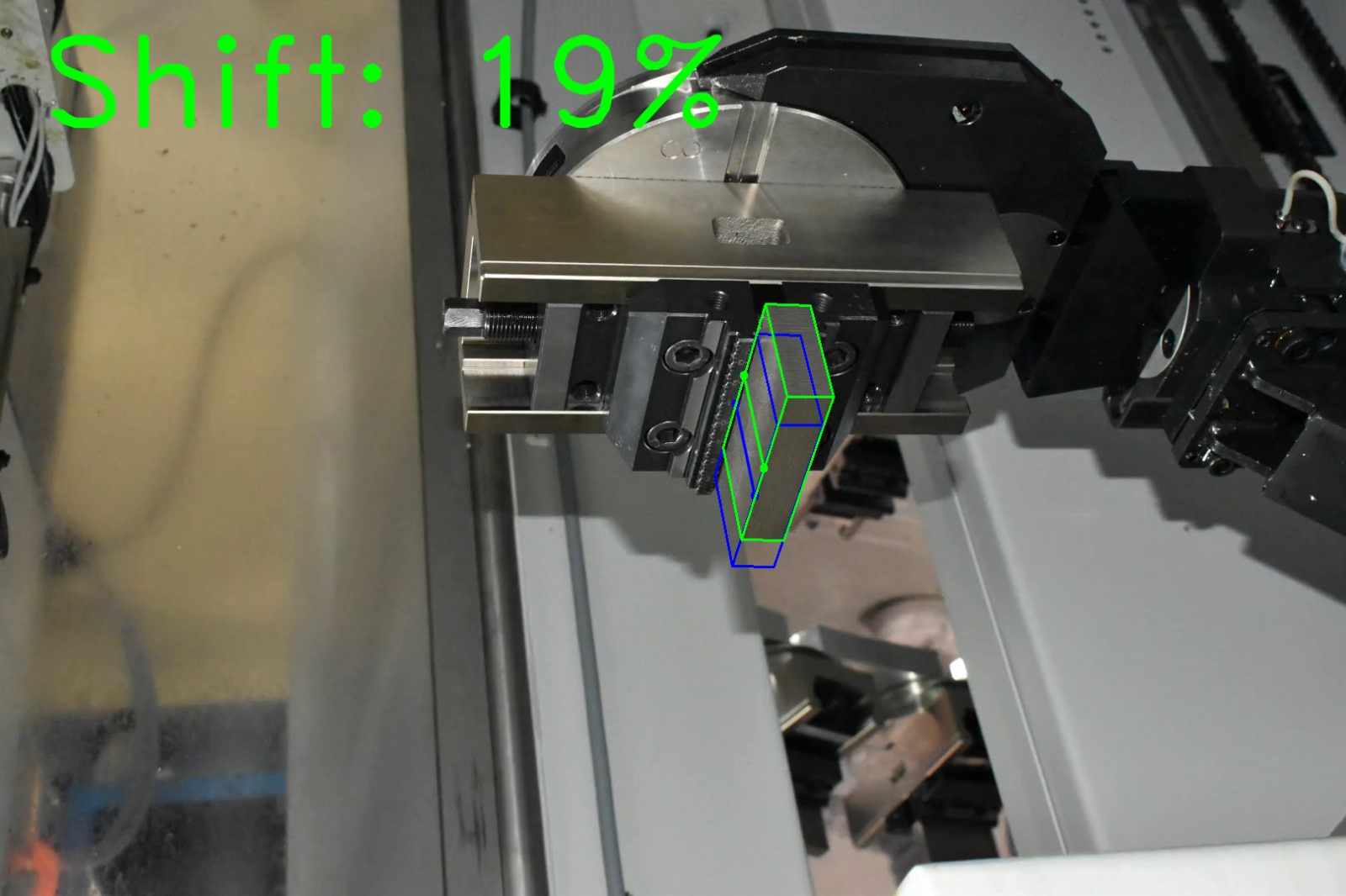 Computer vision shift estimation on factory photograph 14 of a metal block held by a CNC gripper